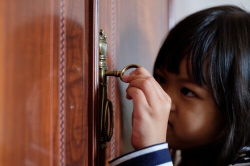 Child using key to unlock door
